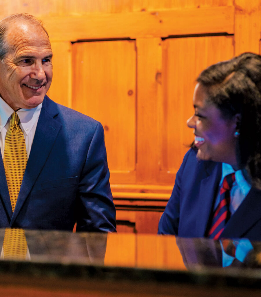 Michael Reynolds, mentor and board member, Bryan School Hospitality and Tourism, with Caudle at the O.Henry Hotel front desk.