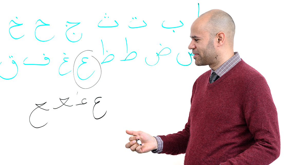 A male professor teaches at a whiteboard